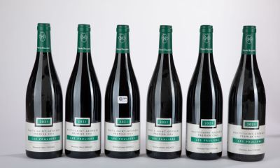 six bouteilles de vin sont alignées sur une table