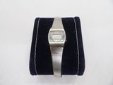 a silver watch on a velvet case on a white surface