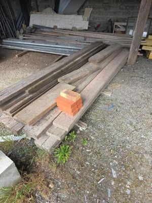 un tas de bois posé par terre à côté d'un tas de briques