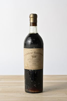an old bottle of wine sitting on top of a wooden table