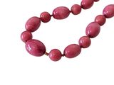 necklace with pink beads on a white background on a white surface