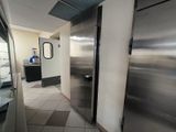 a stainless steel refrigerator in a commercial kitchen next to a counter