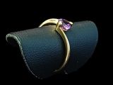 a close up of a gold ring with a purple stone on it