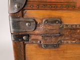 a small wooden trunk with a metal latch on it