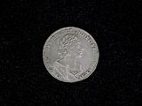 a close up of a silver coin on a black surface