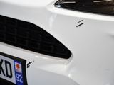 a close up of a white car with a number plate on it