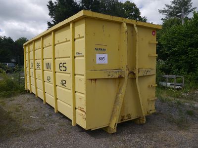 a yellow dumpster sitting in the middle of a field