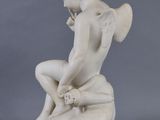 an image of a statue of a boy sitting on top of a rock
