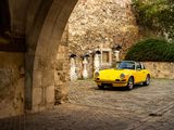 a yellow car that is parked under an arch