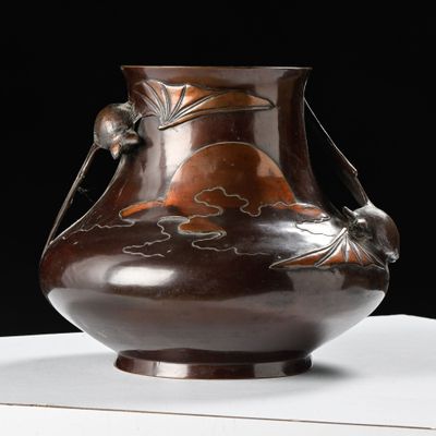 un vase marron posé sur une table sur fond noir