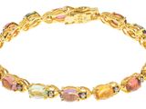 gros plan d'un bracelet en or avec des pierres multicolores