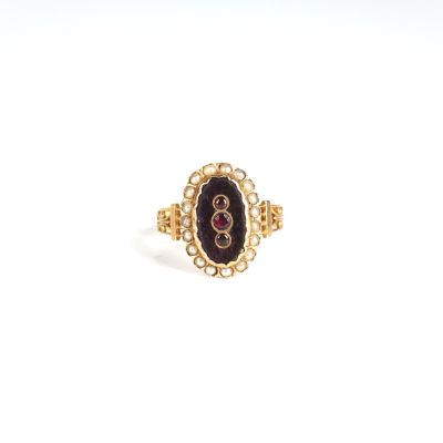 Gros plan sur une bague en or ornée d'une pierre noire