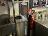 a kitchen with a sink, stove, and shelves in it