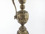 une image représentant un vase doré muni d'une anse, sur fond blanc