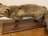 un renard en peluche posé sur une table en bois