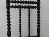 a black wooden chair with a yellow cushion on top of it
