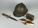 un casque, un couteau et d'autres objets qui se trouvent sur la table