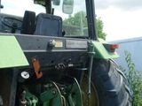 a tractor that is sitting in the grass by a building