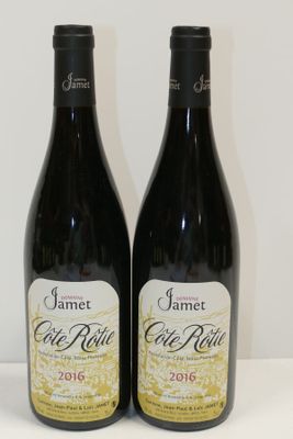 two bottles of wine sitting on a table next to each other