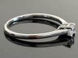 a close up of a diamond ring on a black surface