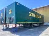 un grand camion vert garé devant un immeuble