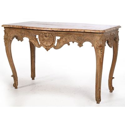 a table with a marble top and carved legs