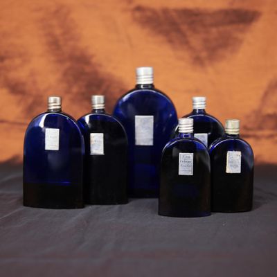 six bouteilles en verre bleues sont alignées en rang sur une table