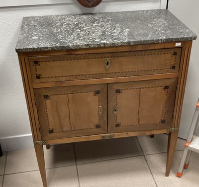 une armoire en bois avec un plan de travail en marbre dans une salle de bains