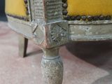 a close up of a chair with a yellow cushion on it
