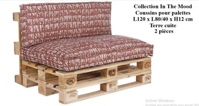 a couch made out of wooden pallets with a red and white cover