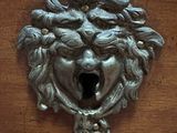 a metal lion head on a wooden door