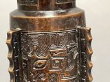 a bronze vase that has a design on it
