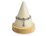 collier posé sur un support en bois, orné d'une croix en argent