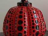 a red and black polka dot pumpkin sitting on top of a table