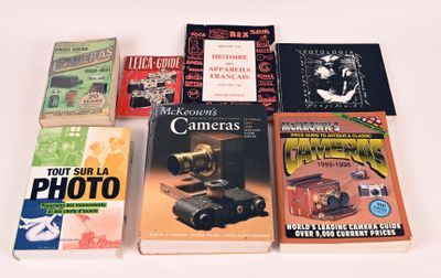 plusieurs livres posés sur une table blanche, avec un appareil photo et d'autres livres
