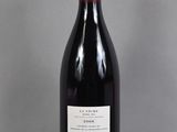 a bottle of red wine sitting on a glass table