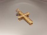 une croix en or posée sur une assiette blanche posée sur une table