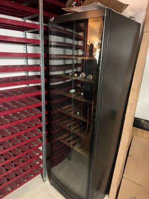 a wine cooler in the middle of a room with shelves