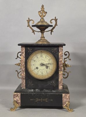 a black and gold clock sitting on top of a table