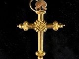 a close up of a gold cross on a black background