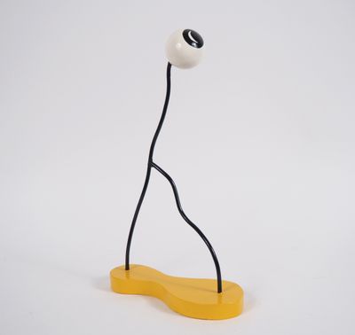 a white and yellow object with a black eye on top of it