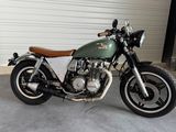a green motorcycle parked in a garage next to a garage door
