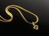 a gold necklace with a snake on a black background