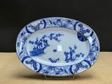 blue and white platter with birds and flowers on it