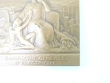 a plaque on the wall of a building with a statue of a woman and a man