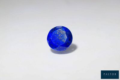 une pierre de saphir bleu sur une surface blanche