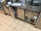 a stainless steel counter with a sink and a bottle of water on it