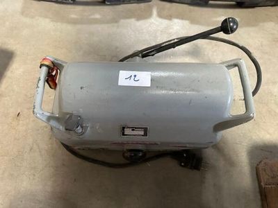 a small air compressor sitting on the floor in the garage