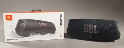 une image représentant une enceinte noire posée à côté d'une boîte