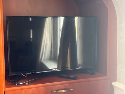 un téléviseur à écran plat posé sur un centre de divertissement en bois